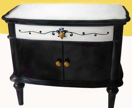 Rjava omarica iz petdesetih let je pobarvana v črno in belo s secisijskim motivom in nadgrajena z novimi zlatimi ročaji